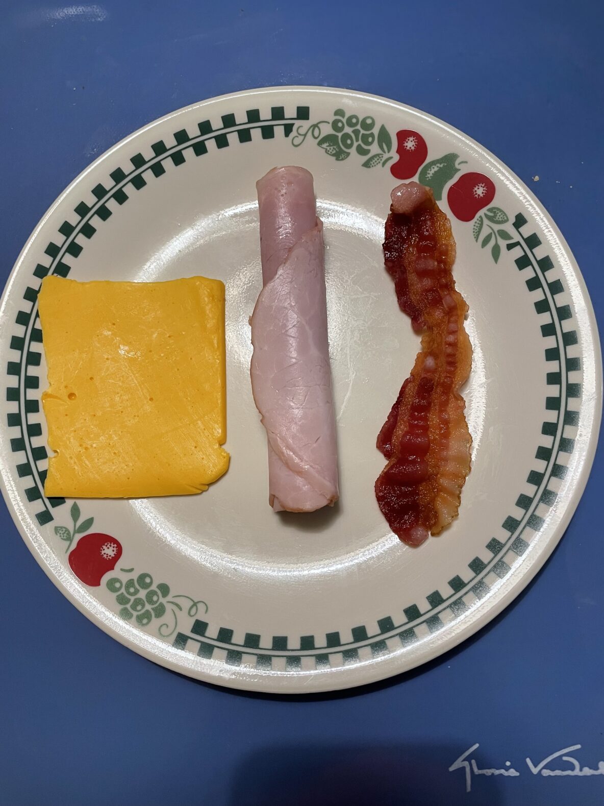 Cheese, ham, and bacon on a plate